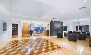 A spacious living area with a checkered floor, a fireplace, and modern furniture. - Crescent Terraza By Alora Reserve (Los Angeles)