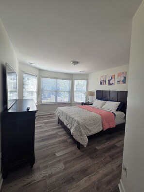 Ein Schlafzimmer mit Bett, Kommode und Bildern an der Wand.
