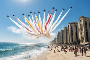 Ein Strand mit einer Formation von Düsenjets am Himmel.