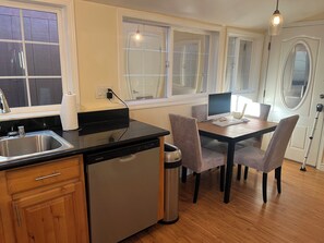 Une cuisine équipée d’un lave-vaisselle, d’un évier et d’une table à manger avec des chaises.