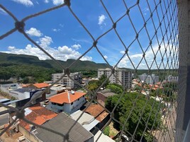Vista de uma área residencial com edifícios e montanhas ao fundo.
