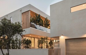 A modern two-story building with a balcony, large windows, and a stone facade. - La Jolla Reverie By Alora Reserve (Los Angeles)