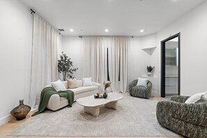 A modern living room with a sofa, armchair, and coffee table. - Fuller Celestia By Alora Reserve (Los Angeles)