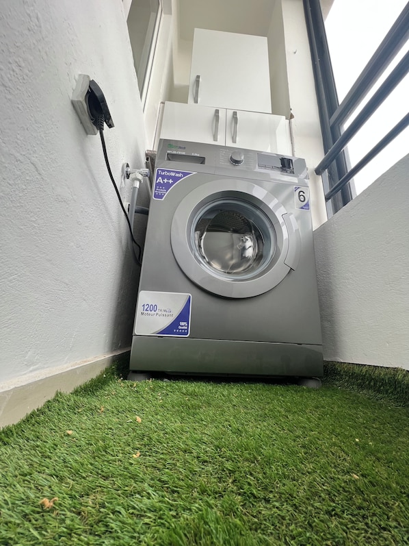 A front-loading washing machine with a label indicating a 1200 RPM motor and a TurboWash A++ rating.