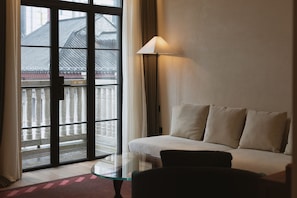 A hotel room with a sofa, a glass coffee table, and a view of traditional architecture through a large window. - Hylla Casa (Chongqing)