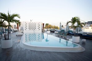 Zona piscina al terrat amb gandules i palmeres.
