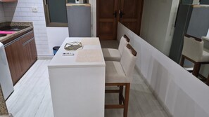 A compact kitchen with a white countertop, a small table, and a chair. - Luxury Apartment Near Ipanema Beach Rio de Janeiro (Rio de Janeiro)