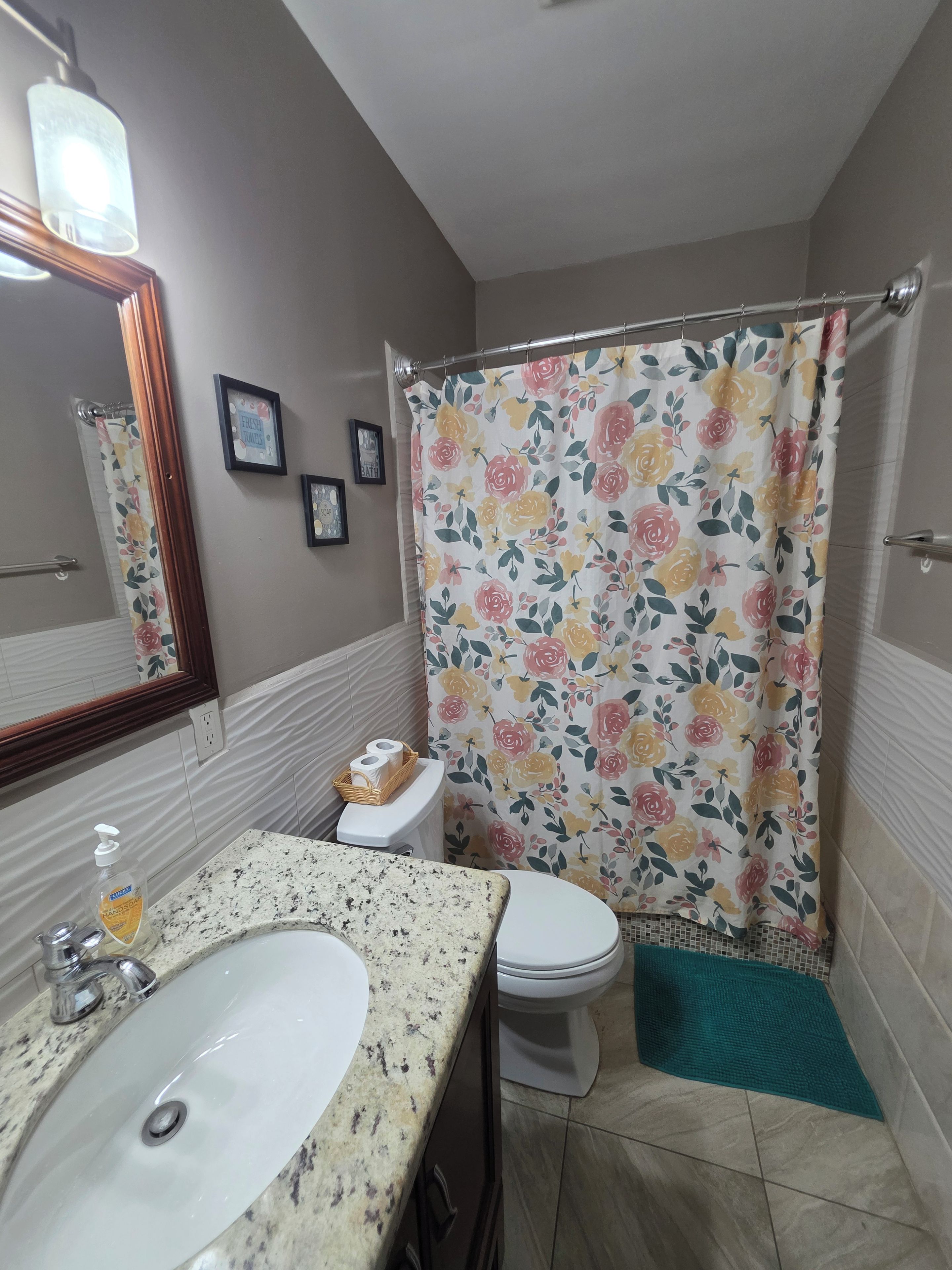 Ein Badezimmer mit Waschbecken, Toilette und Duschvorhang.