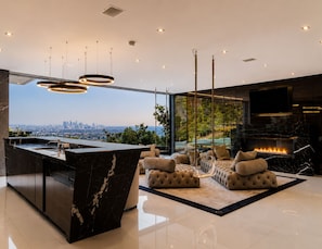 Un interior moderno con una barra de mármol, zona de estar y vistas a la ciudad.