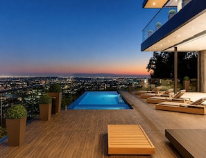 Una piscina en la azotea con vistas a la ciudad al anochecer.