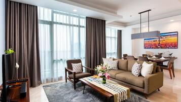 Una sala de estar moderna con un sofá, sillones, una mesa de centro y un televisor.