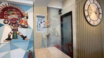 A reception area with a marble counter, a wall clock, and a colorful mural.