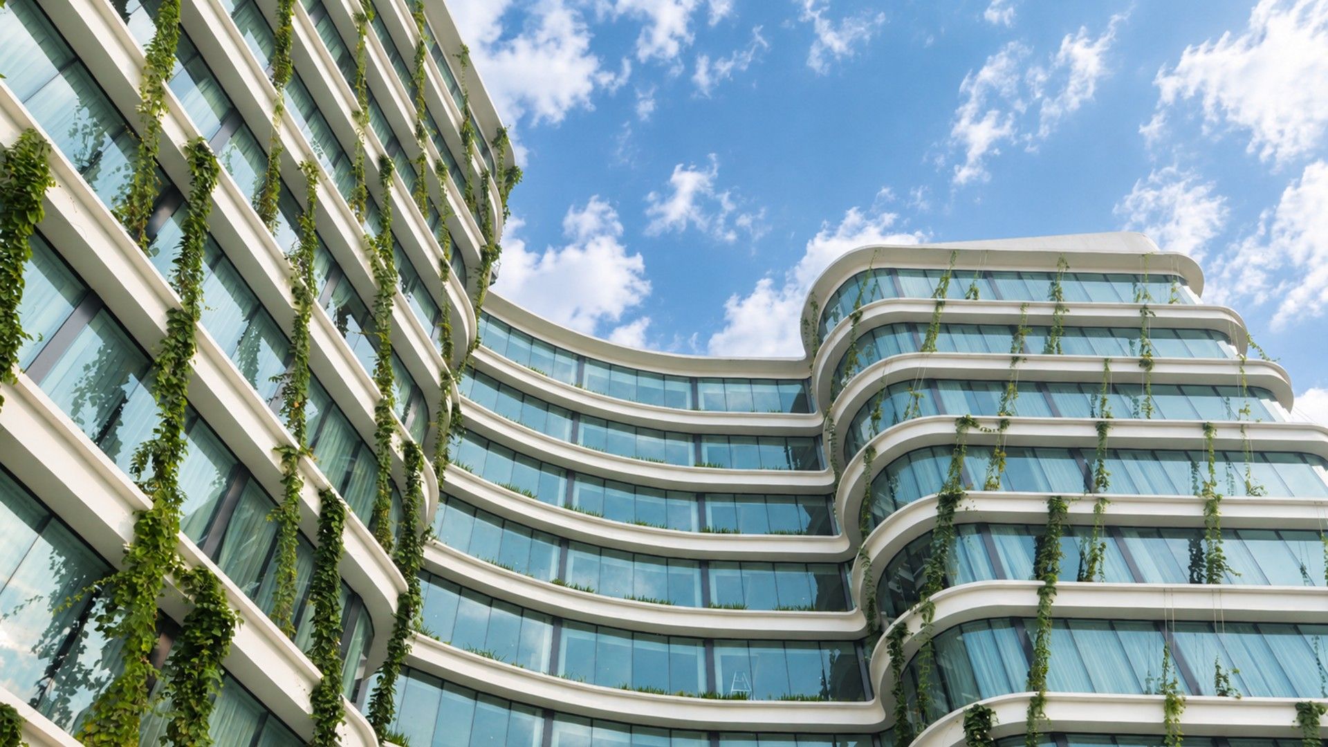 Un edificio moderno con arquitectura curvilínea y amplios ventanales de vidrio.