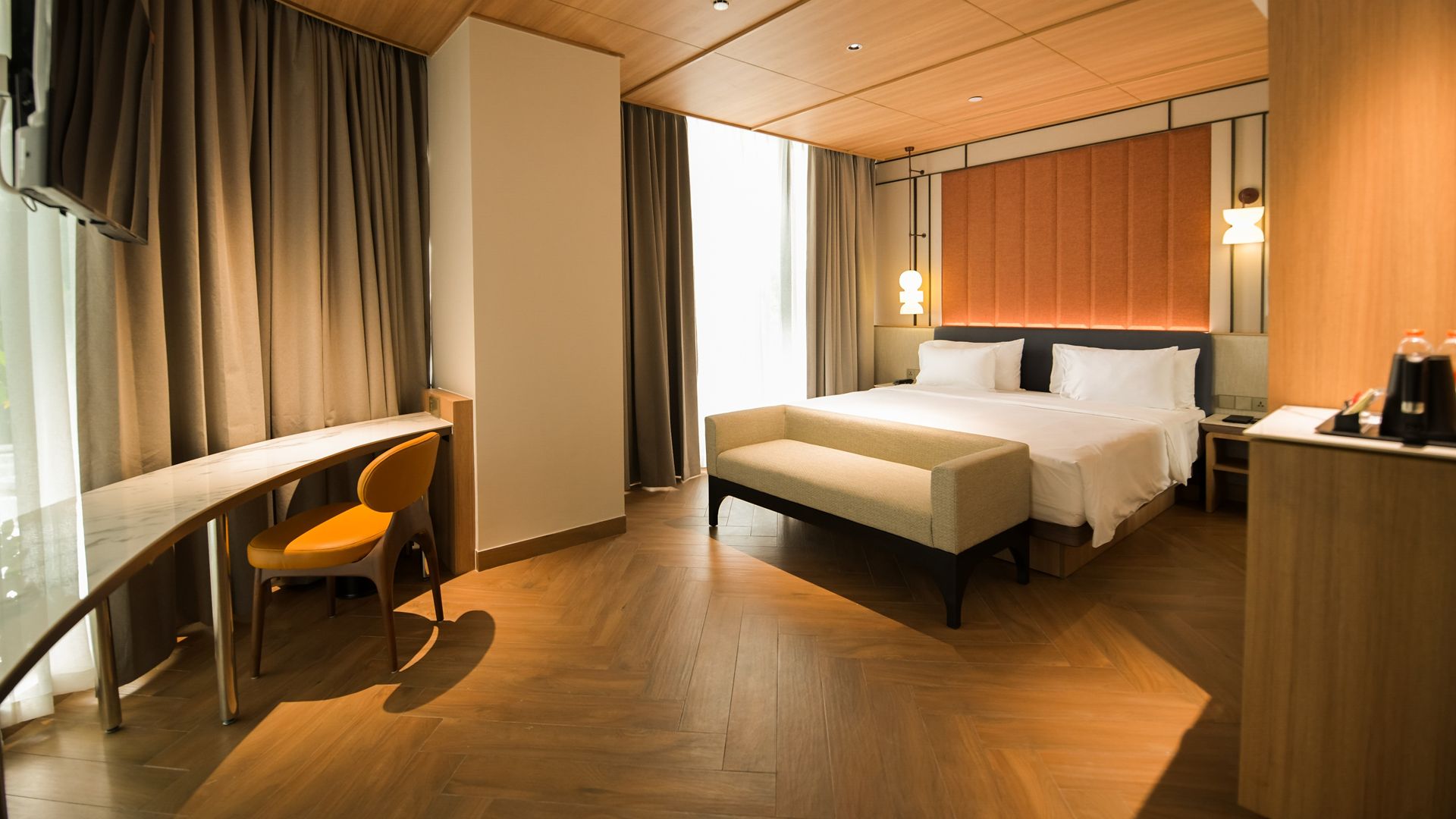 Una habitación de hotel con una cama, un escritorio, una silla y una mesita de noche.
