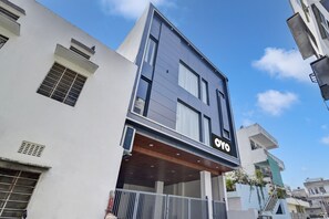 A modern building with a prominent 'OYO' sign, a flat roof, and a balcony with railings. - Hotel O Salasar Inn (Jaipur)