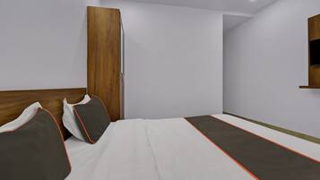 Ein Schlafzimmer mit einem Bett, Kissen, einem Holzschrank und einem an der Wand befestigten Regal.