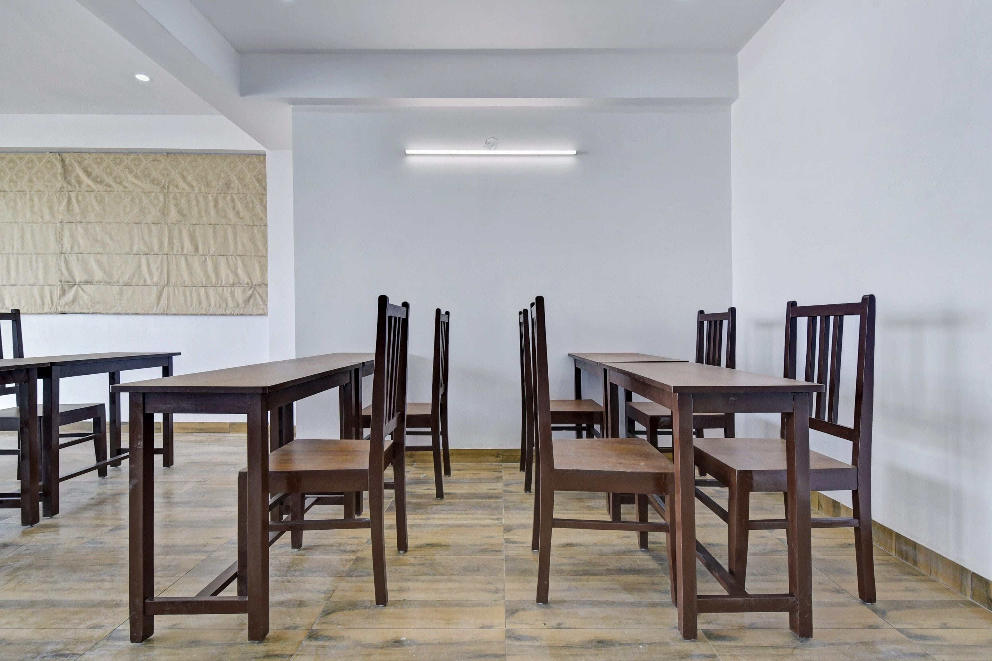 Una habitación con varias mesas y sillas de madera dispuestas para comer.