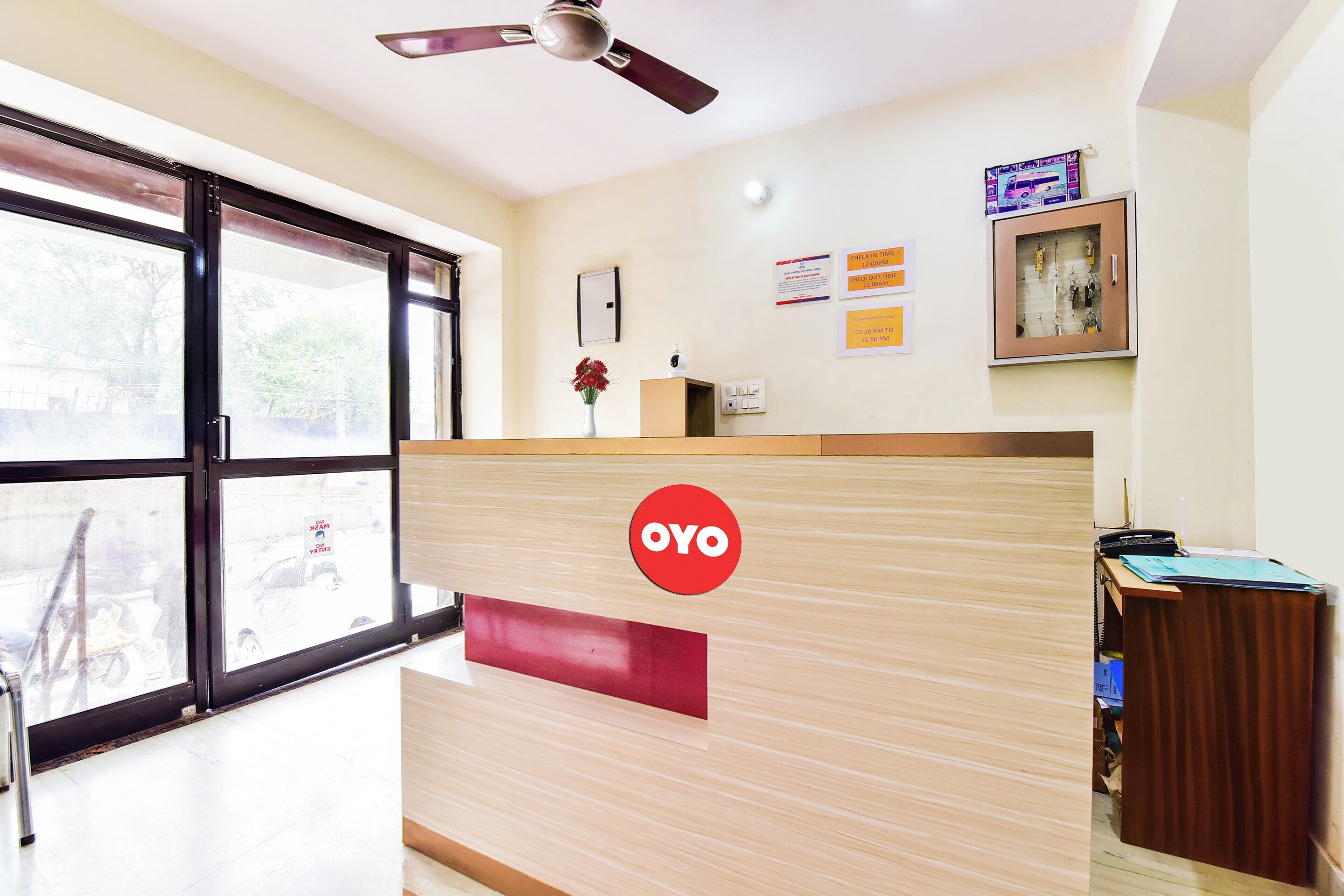 A reception desk with a logo, a clock, and a window with a view of the outside.