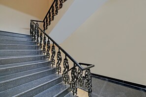 Un escalier orné de rampes en métal noir et de marches en marbre foncé.