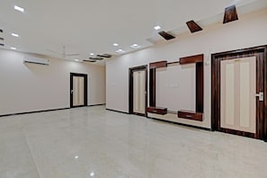 Un pasillo de hotel con piso de mármol pulido, iluminación empotrada en el techo y puertas numeradas 201 y 203.