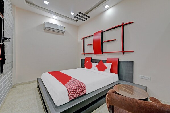 Une chambre d’hôtel moderne, équipée d’un lit, d’une petite table ronde et d’un climatiseur fixé au mur.