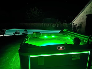 A hot tub with green lighting, a pool, and outdoor seating. - New Listing (Farges-Allichamps)
