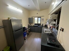 A compact kitchen with a refrigerator, stove, sink, and cabinets.