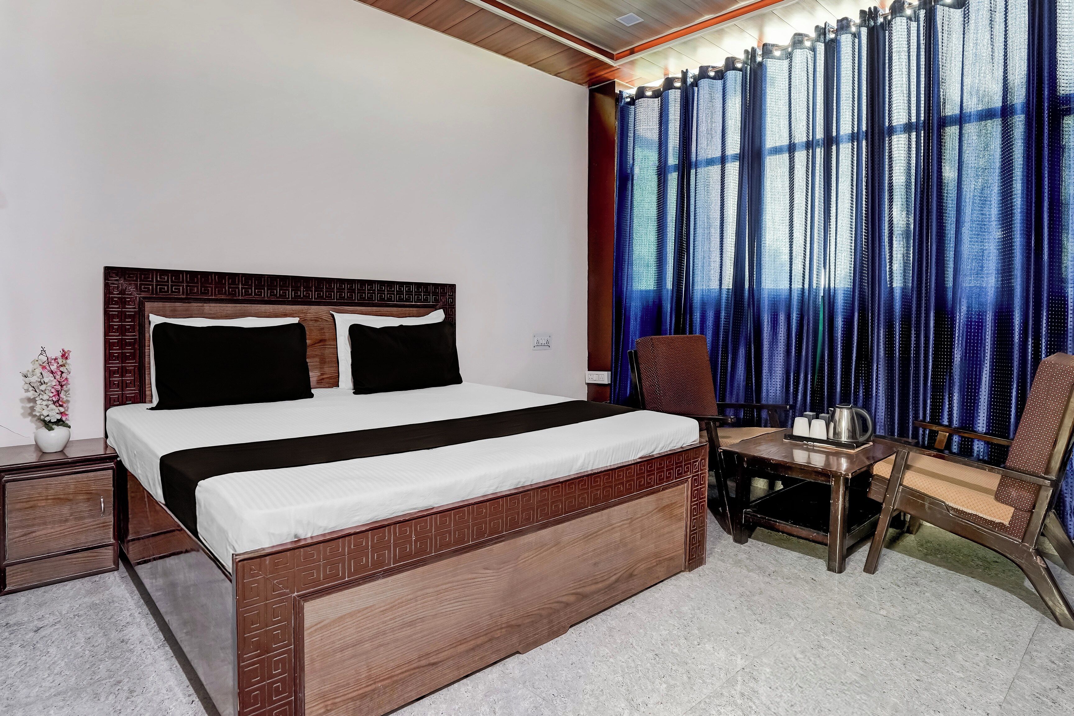 A hotel room with a bed, a desk, and a chair.