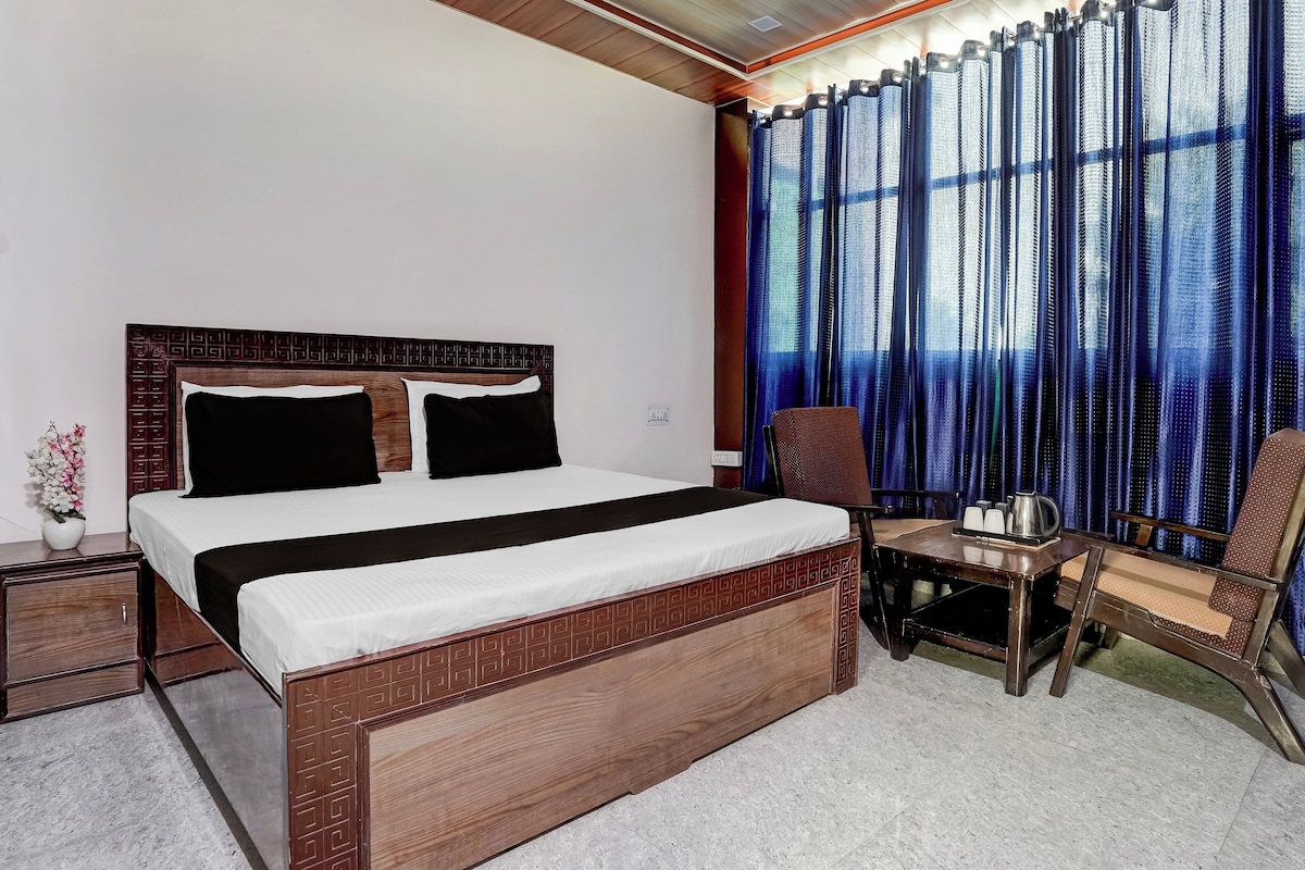 A hotel room with a bed, a desk, and a chair.