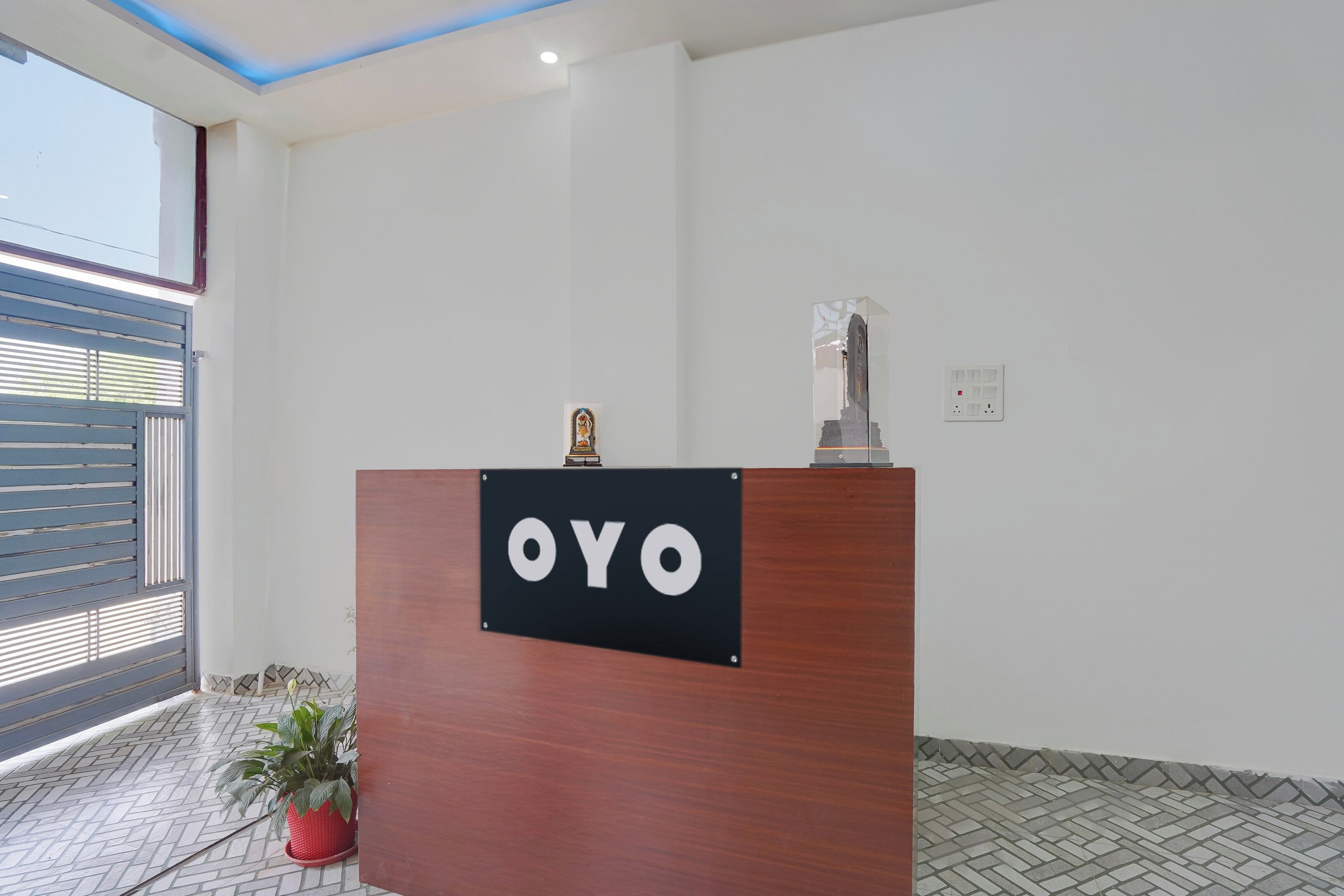 A reception desk with a sign that reads 'OYO' and a small statue on top.