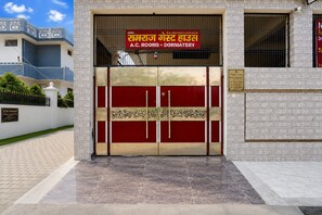 Entrada a un edificio con un letrero que dice A.C. ROOMS DORMATERY.