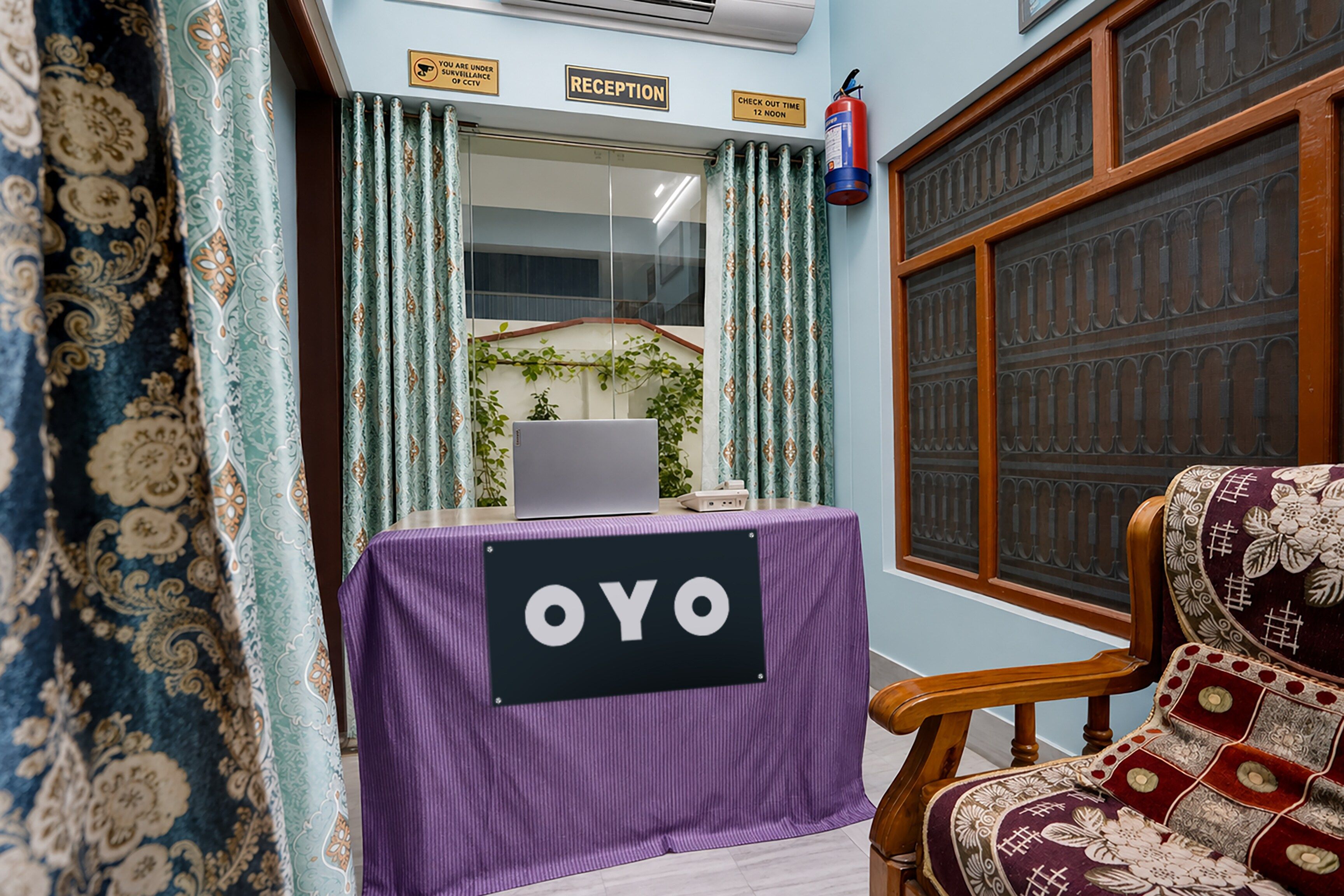A reception area with a reception desk, a laptop, and a chair.