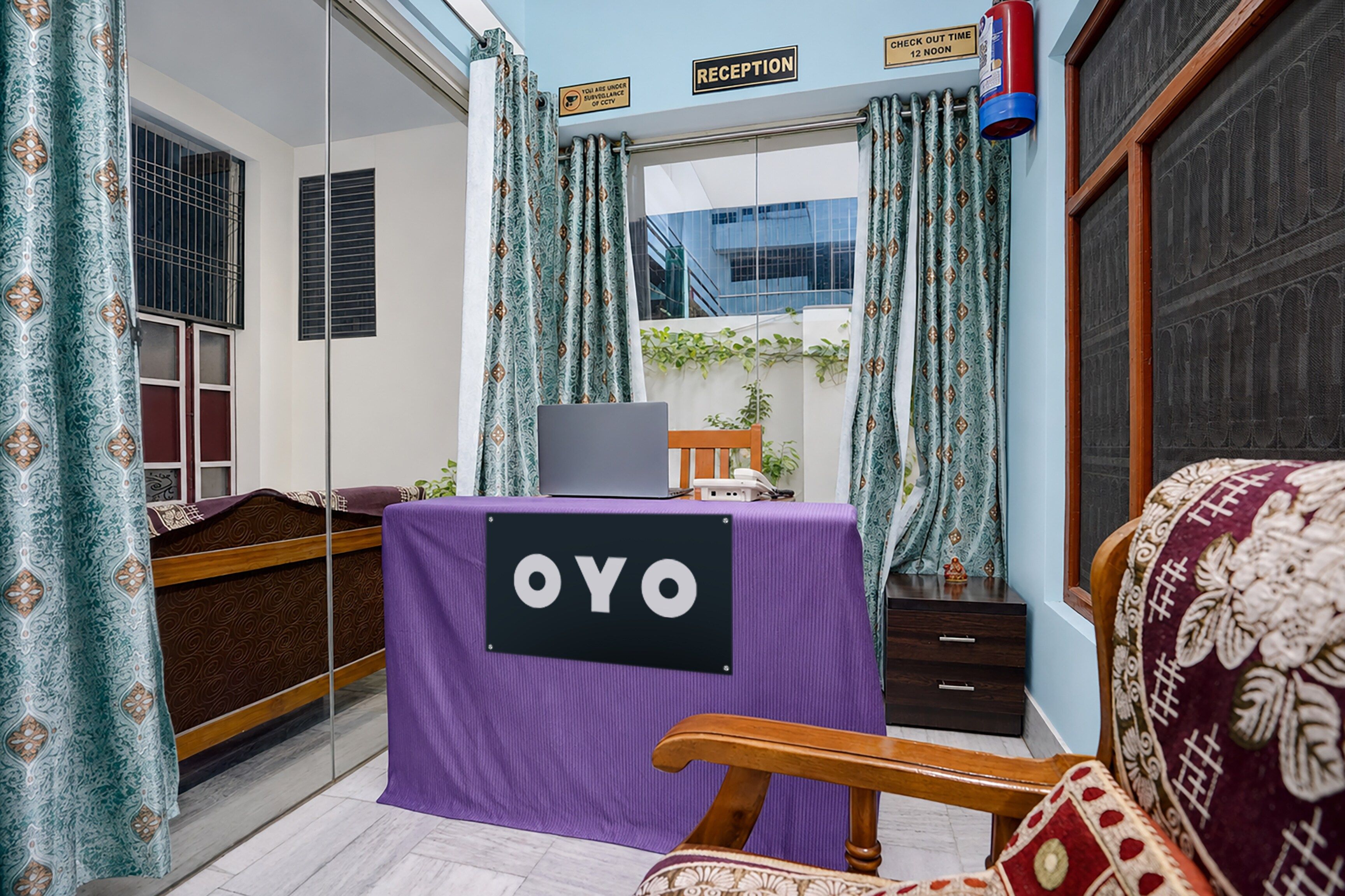 Una camera d'albergo con reception, un letto, una sedia e vista sull'esterno.