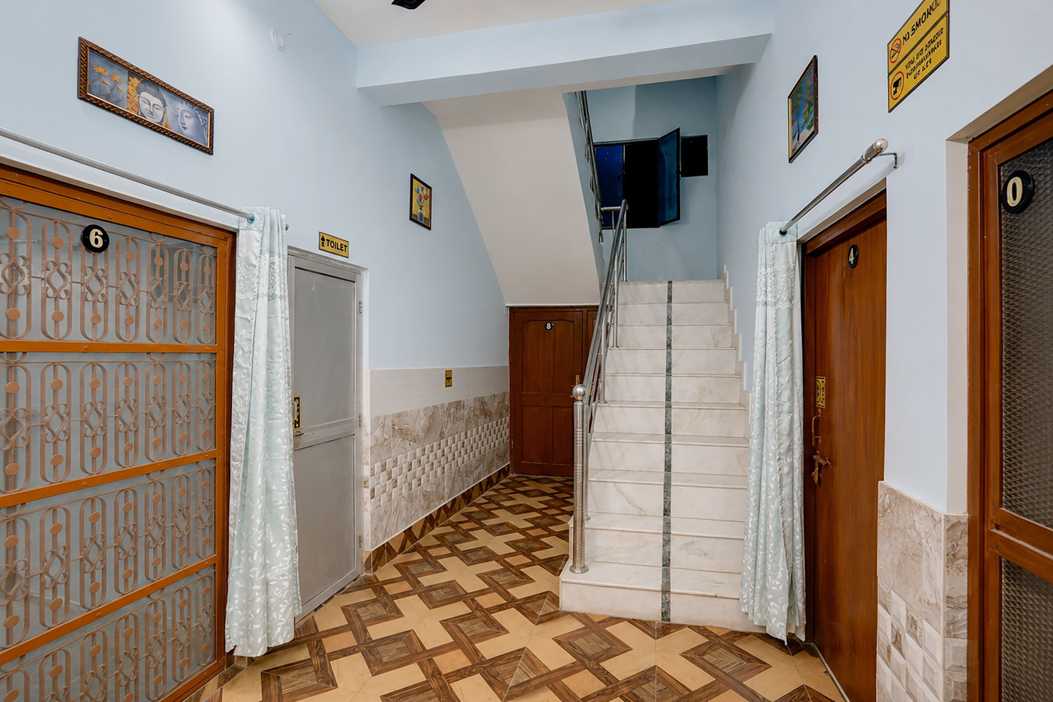 Un pasillo con suelo de baldosas, una escalera y puertas con los números 6, 4 y 8.