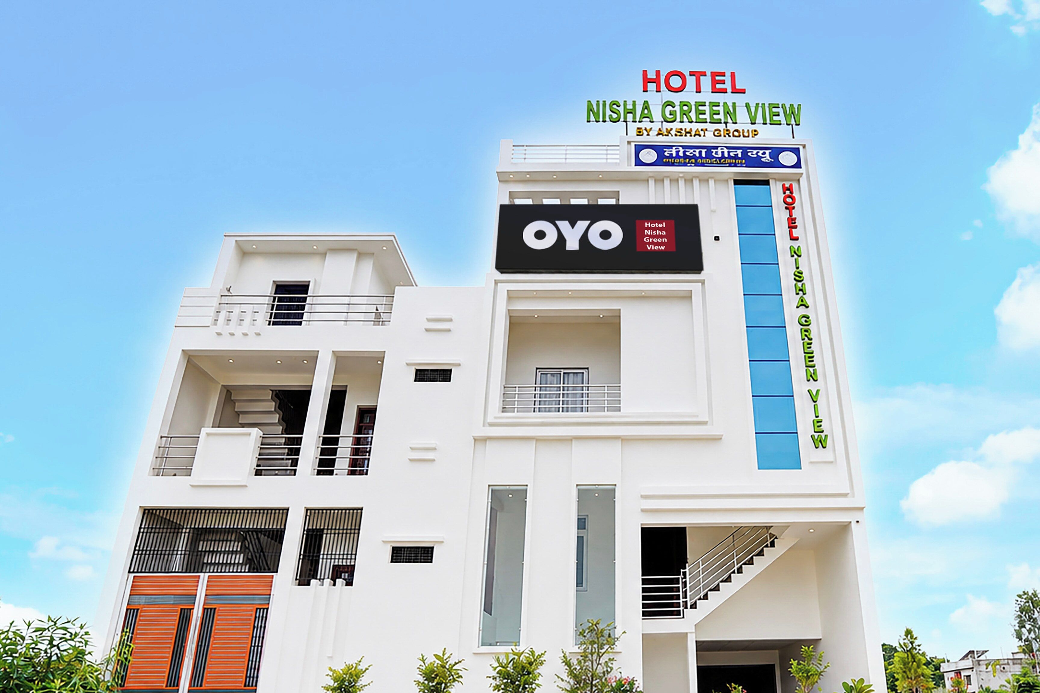 A multi-story hotel building with signage for 'Hotel Nisha Green View' and 'OYO'.