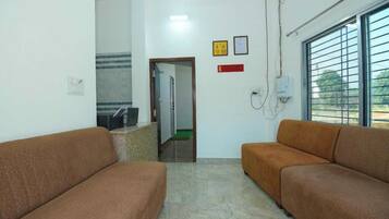 A waiting area with two sofas, a reception desk, and a window with blinds.