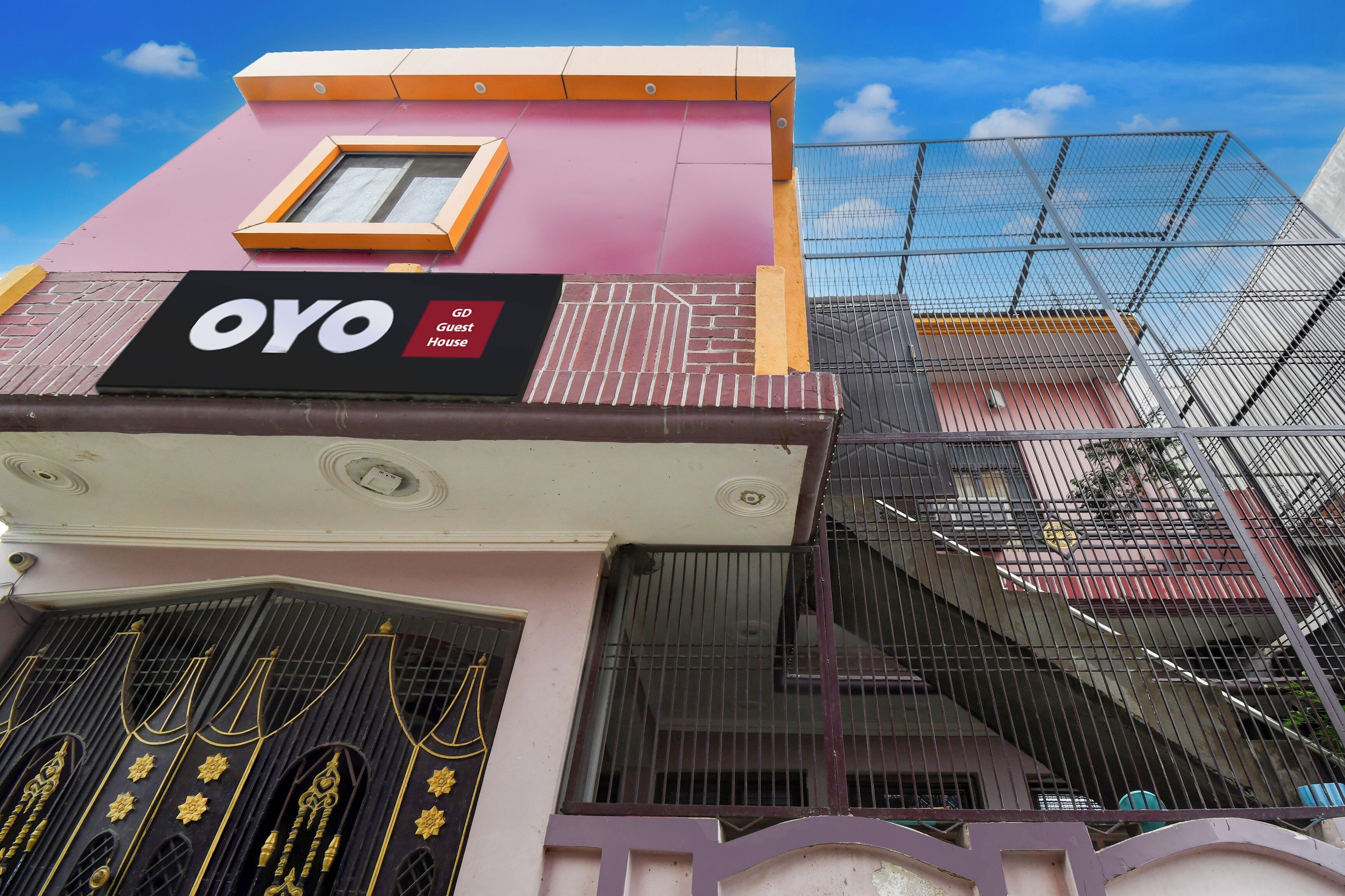 A building with a sign reading 'OYO Guest House' and a window above it.