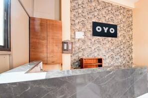 Ein Empfangsbereich mit einer Wand aus Steinmosaik und einem Schild mit der Aufschrift 'OYO'.