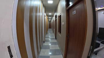 A corridor with a checkered floor, striped walls, and a door marked with the number 101.
