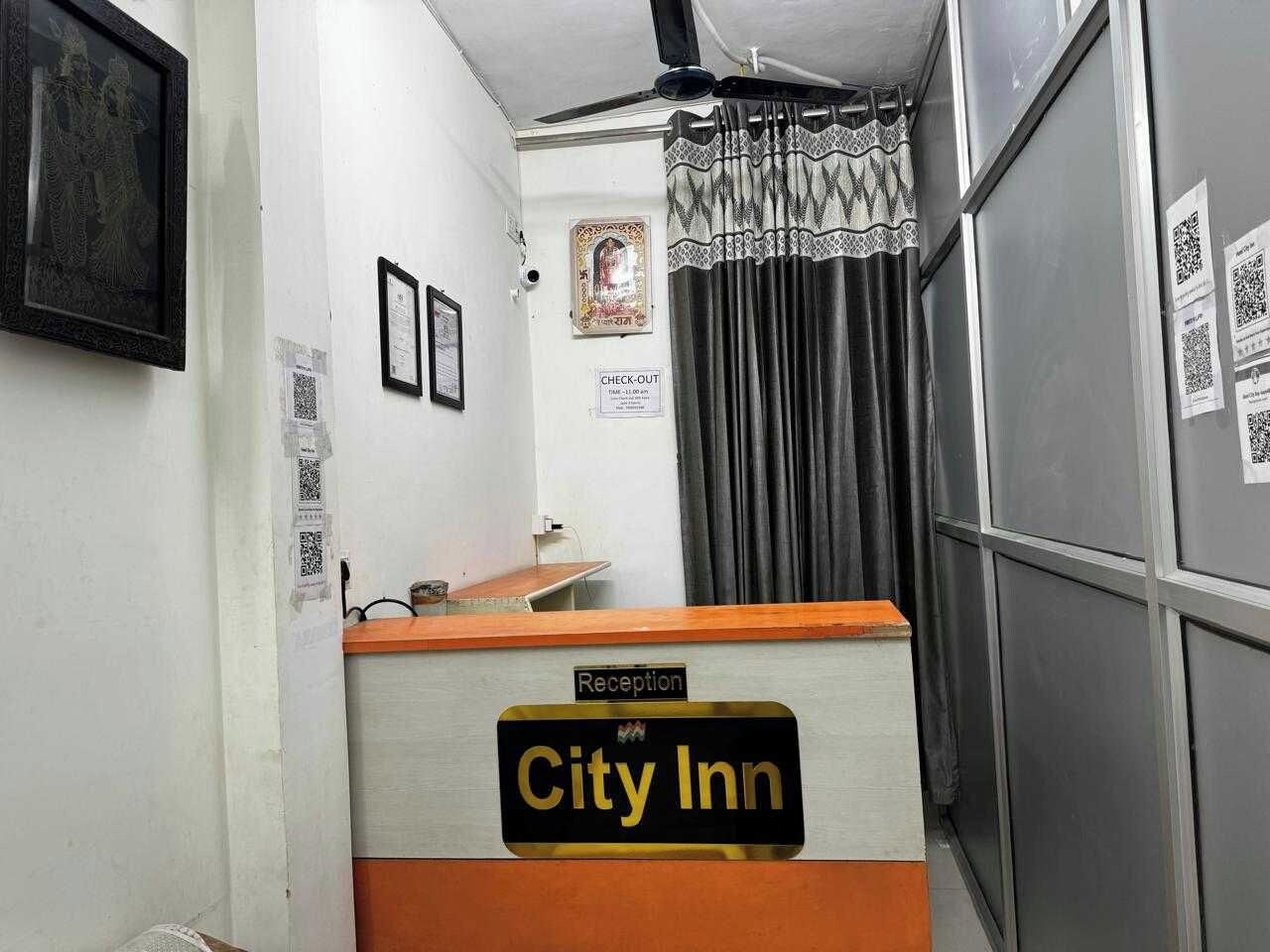 A reception desk with a sign reading 'City Inn' and a 'Reception' label above it.