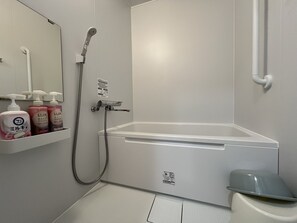 A bathroom with a bathtub, a shower, and a toilet. There are toiletries on a shelf. - Smart House Miduho (Kuma District Nishiki)