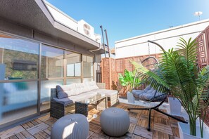 A rooftop patio with a sofa, two round ottomans, a hanging chair, and potted plants. - New Home Renovated 1 Min walk to Train Station 6 Min Ride to Namba. Nankai Line! (Osaka)