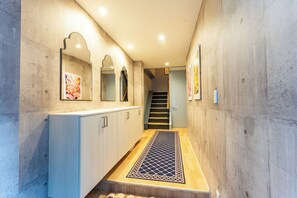 A hallway with a wooden floor, a metal grate, and a staircase leading to another level. - New Home Renovated 1 Min walk to Train Station 6 Min Ride to Namba. Nankai Line! (Osaka)