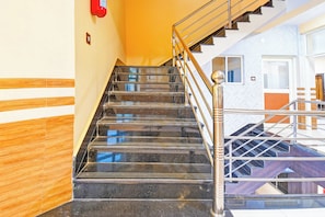 A staircase with a metal handrail and a red fire extinguisher on the wall.