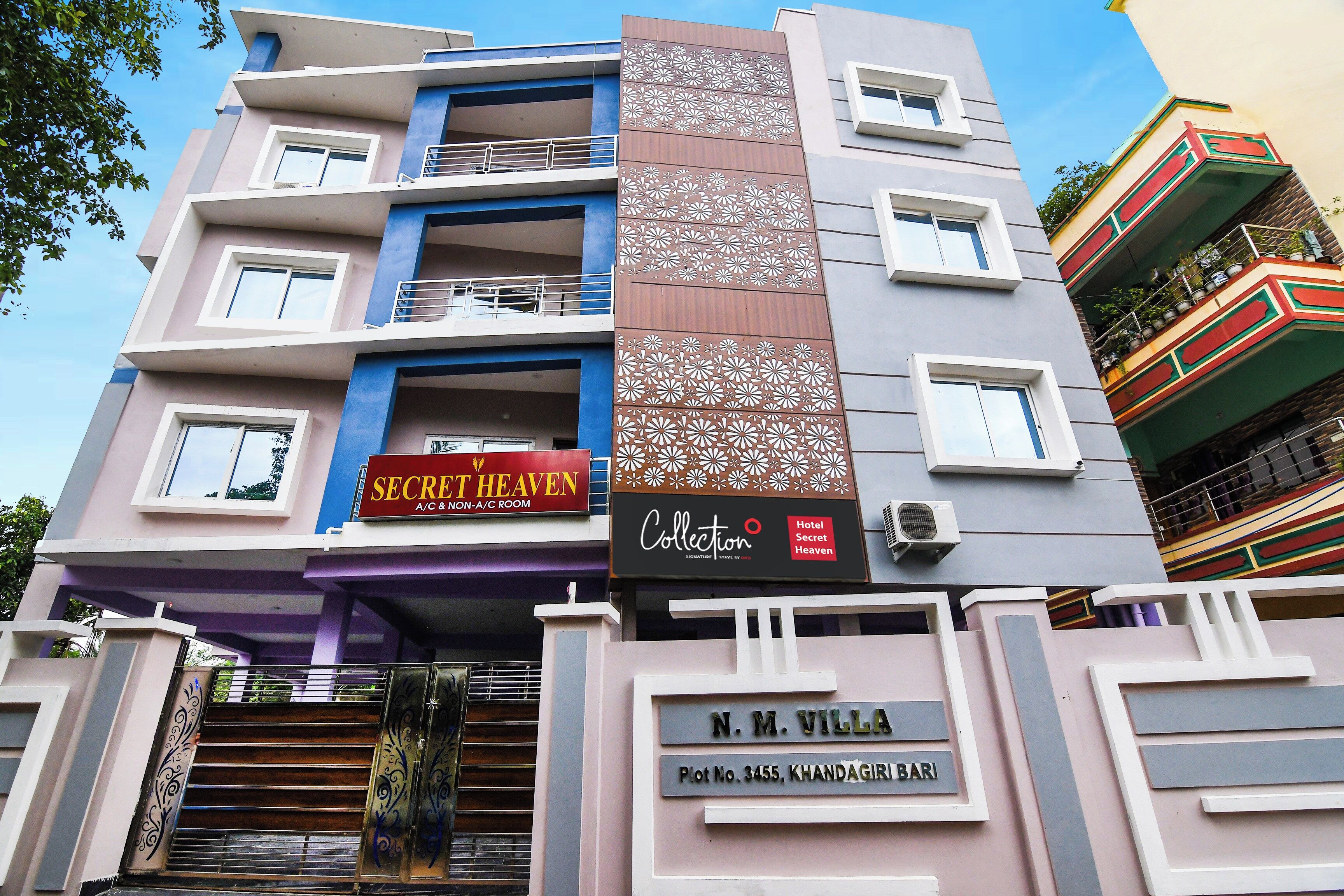 A multi-story hotel with balconies, a sign for 'Secret Heaven A/C & Non-A/C Room,' and a 'Collection' sign.