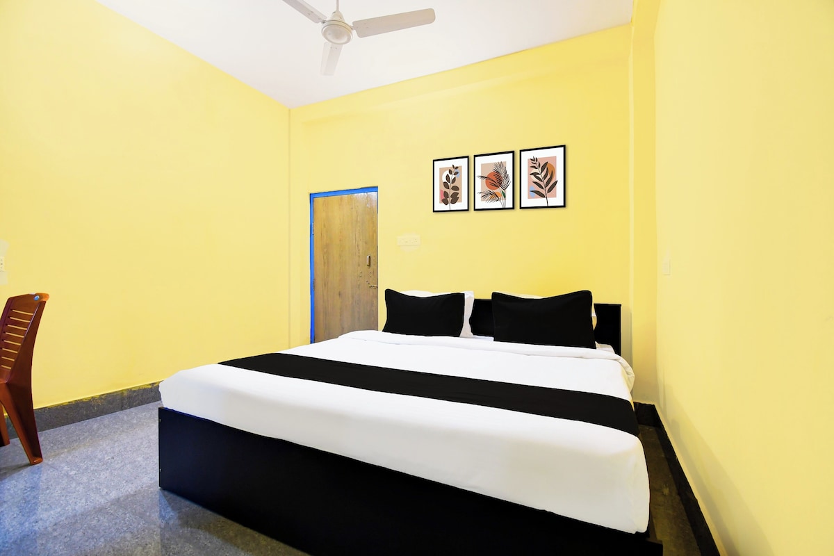 Una habitación con una cama, un ventilador de techo y tres cuadros en la pared.