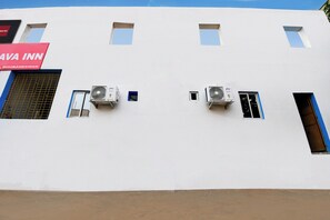 Um edifício com várias janelas e aparelhos de ar condicionado na fachada.