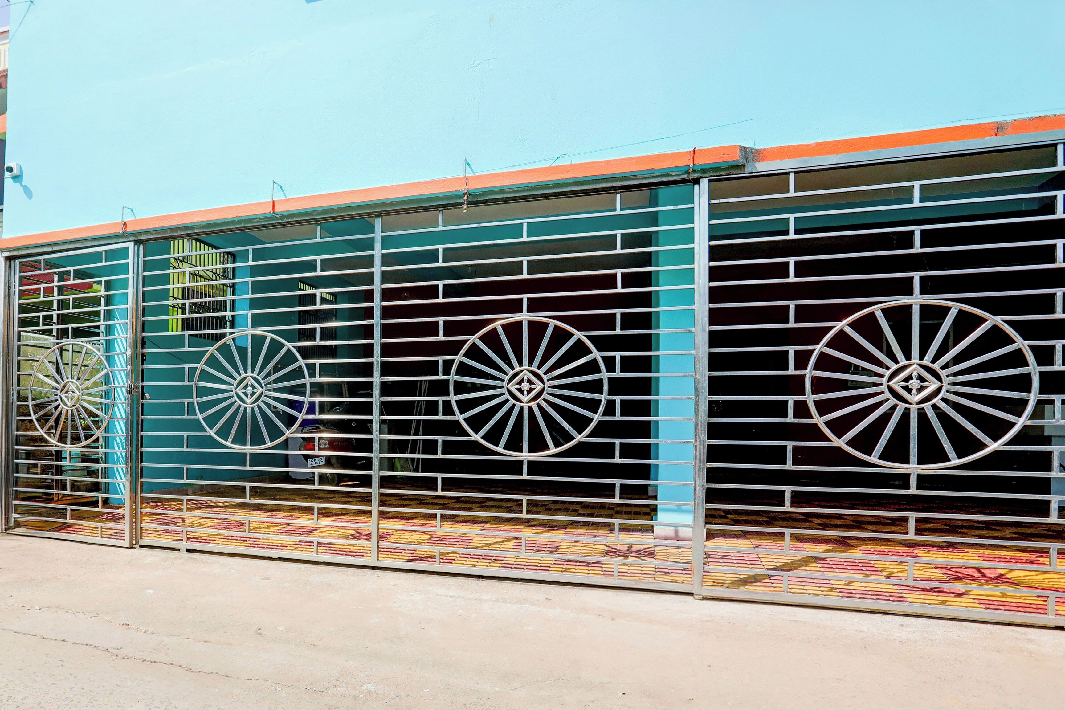 A building with a metal fence and decorative wheels.