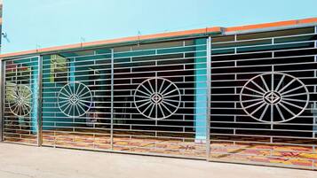 A building with a metal fence and decorative wheels.