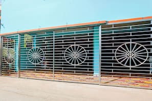 Un edificio con cerca de metal y ruedas decorativas.